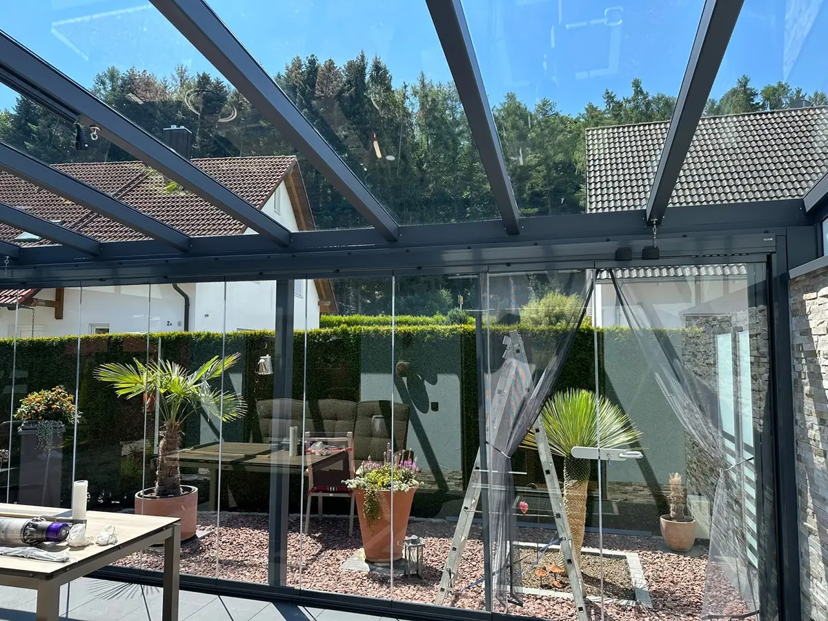 Klar gereinigte Glasschiebewände und Glasdach im Wintergarten nach der Reinigung