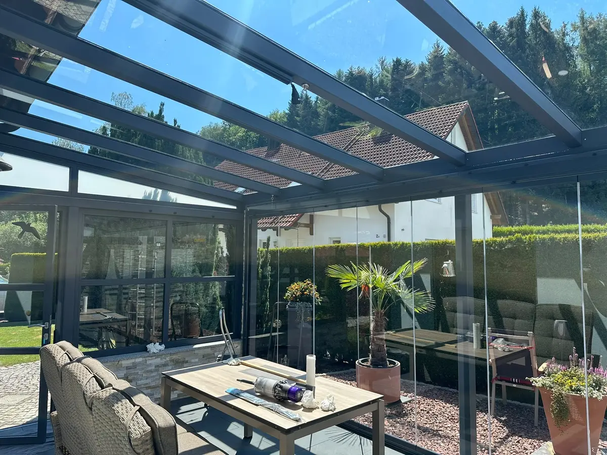 Wintergarten mit Glasdach und Glasschiebewänden vor der Reinigung